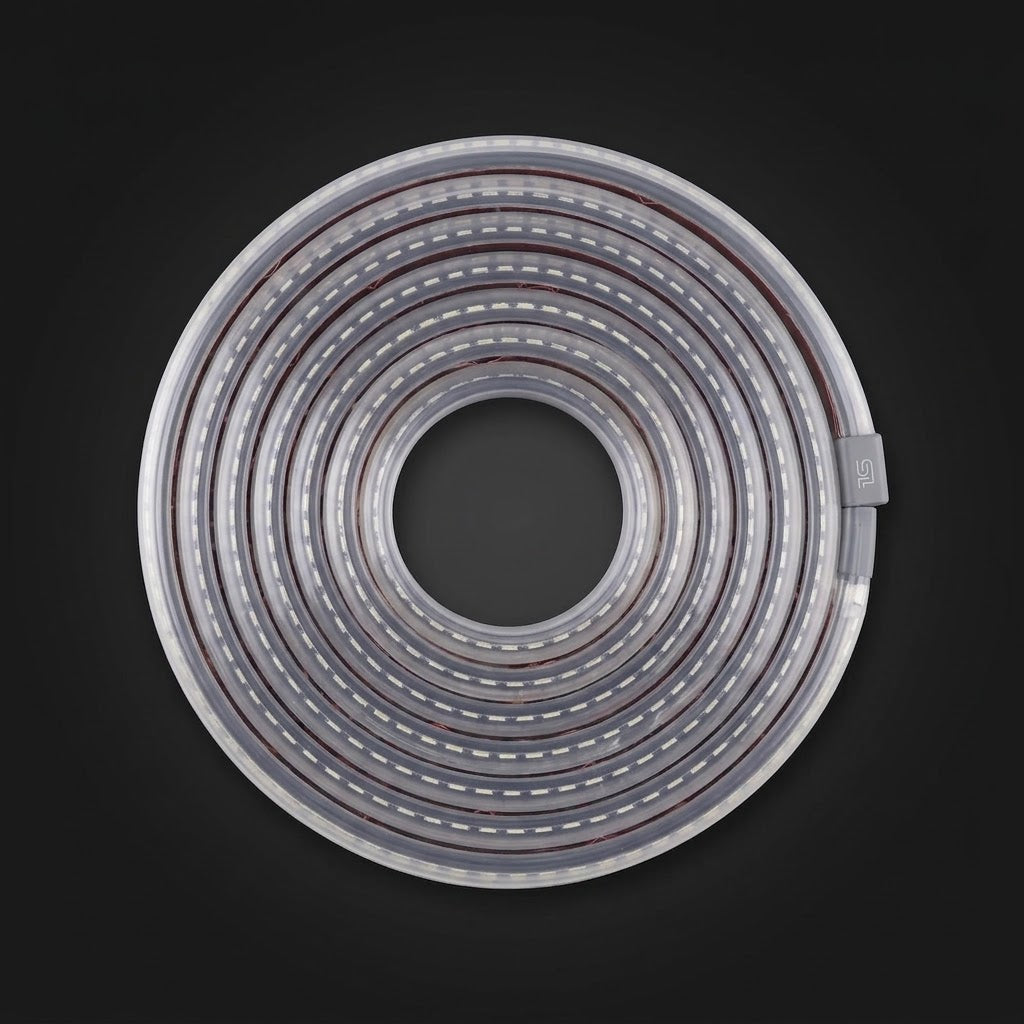 Wheel light replacement strip coiled flat and unlit on a dark background, gray connector at the end