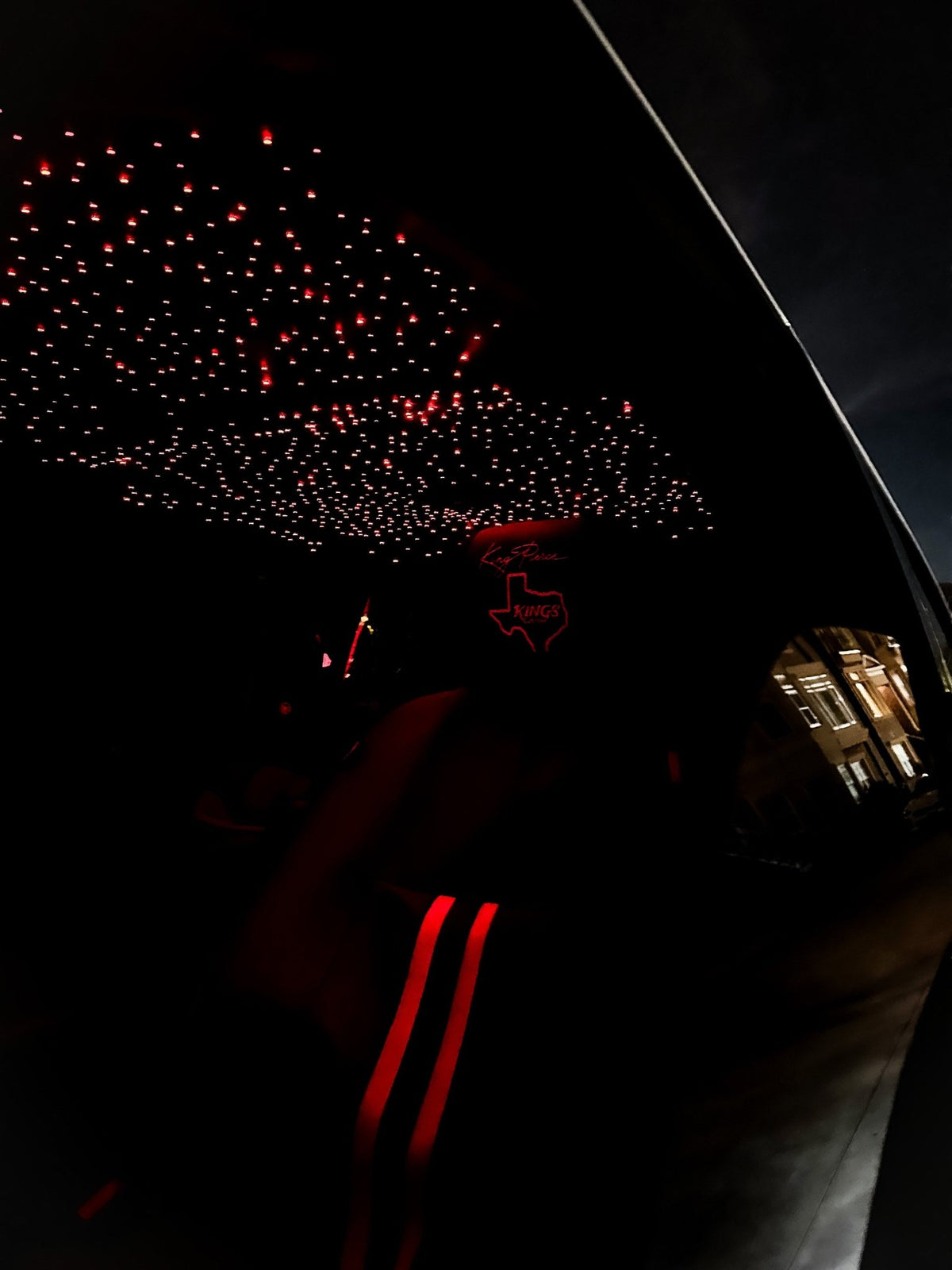 Starlight headliner set to red inside a truck cab at night, the stars glowing red over the front seats